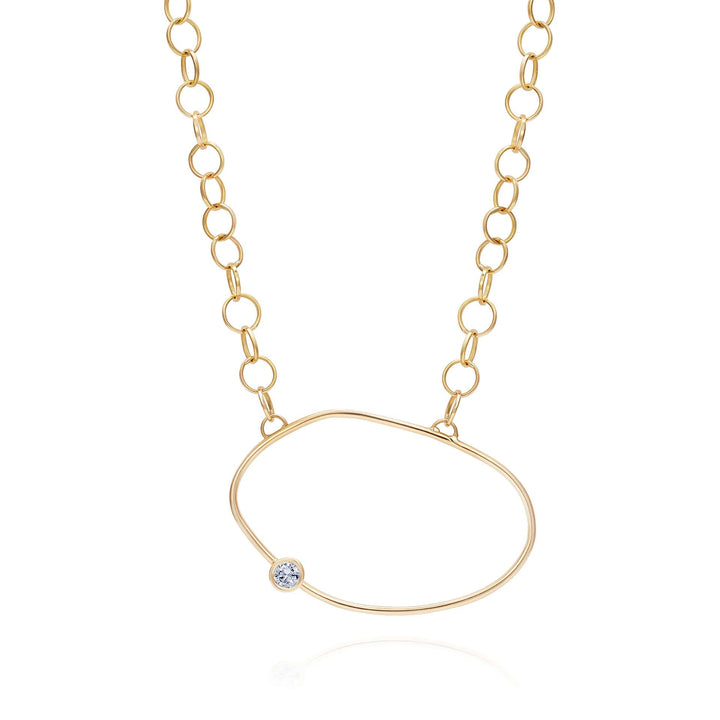 Yellow Gold necklace with an asymmetric oval pendant with a white diamond off the centre - inspired by a cell.